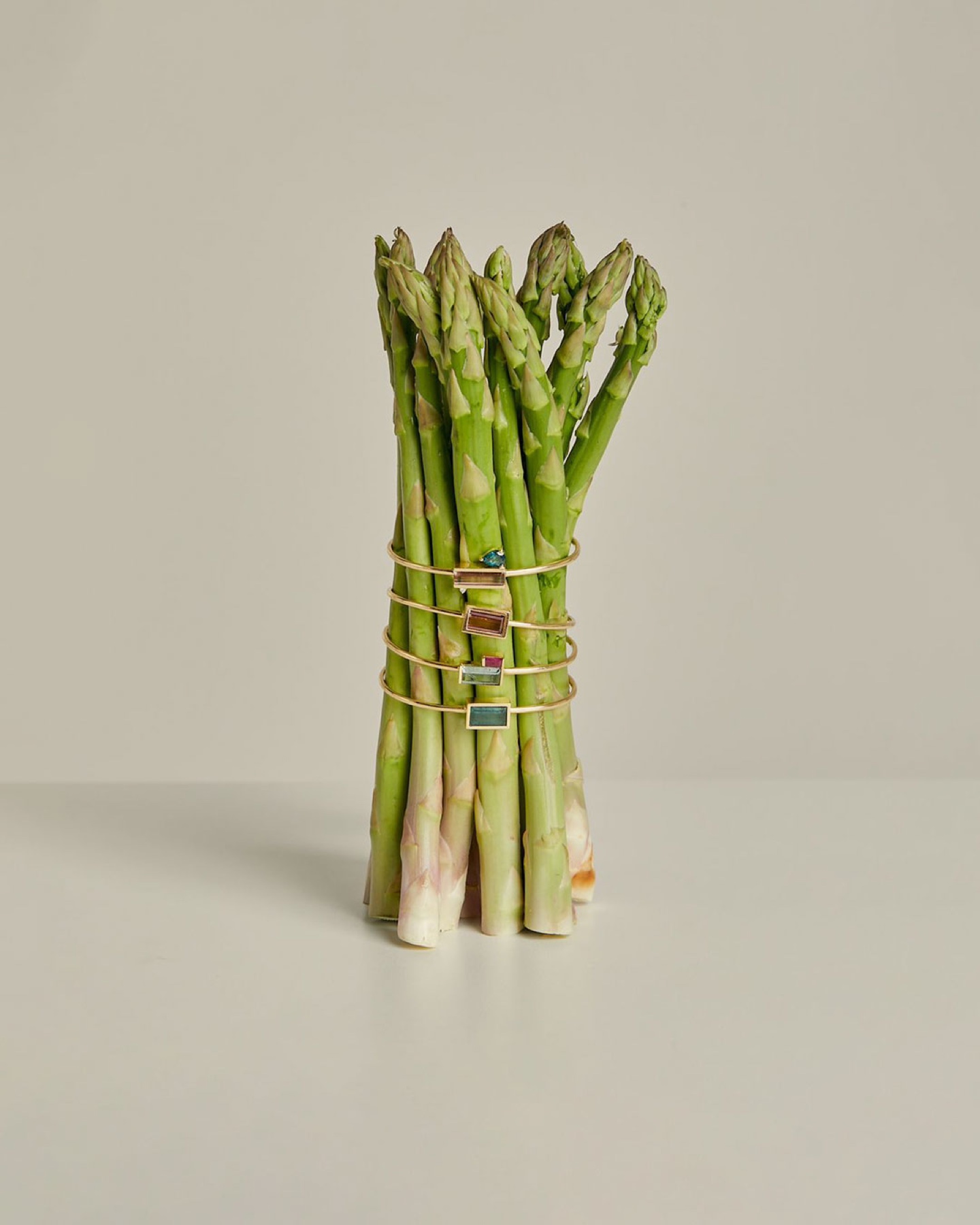 Carolina Neves bracelets arranged around a sculptural bundle of asparagus