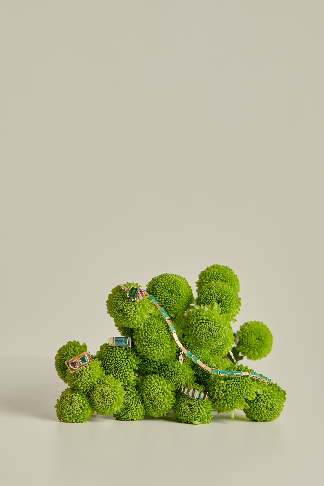 Carolina Neves jewelry styled with a sculptural green floral arrangement