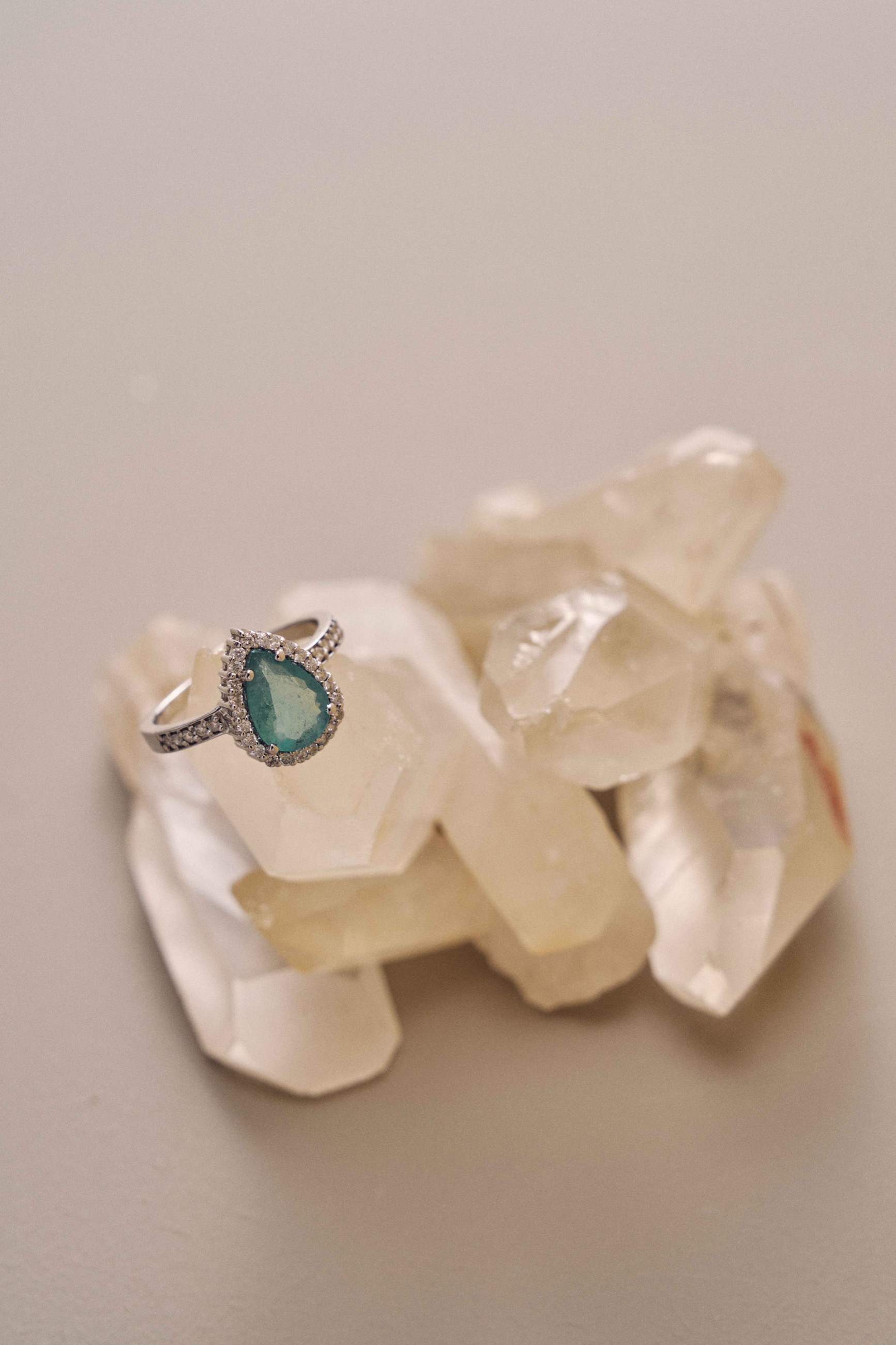 Green gemstone ring arranged on translucent crystals