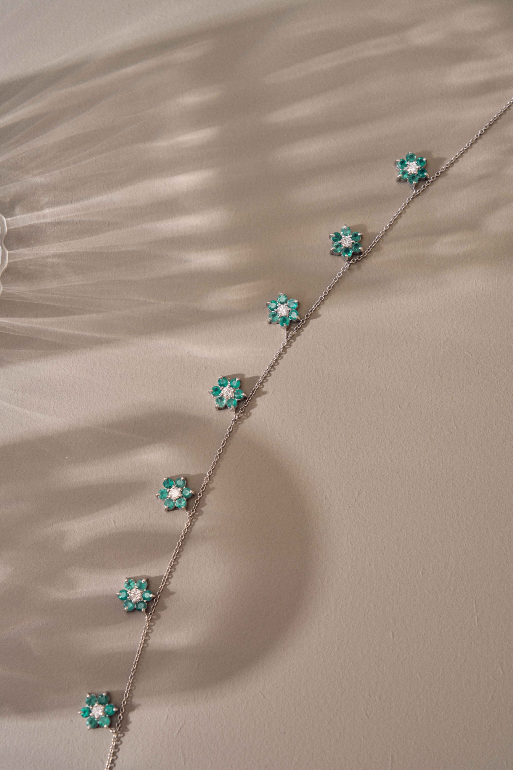 Emerald flower necklace arranged as a sculptural still life
