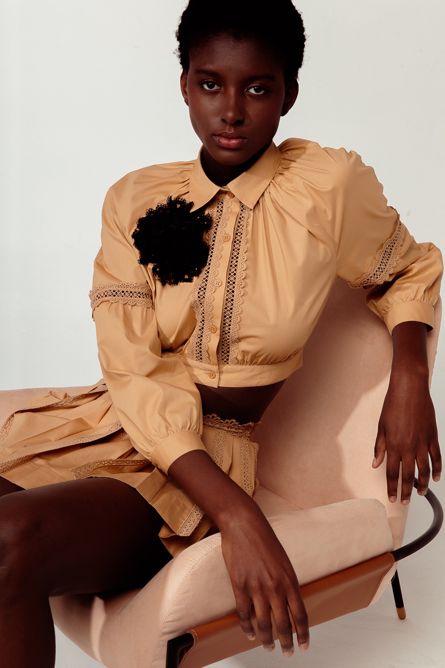La Gea model seated in a sand-toned lace look