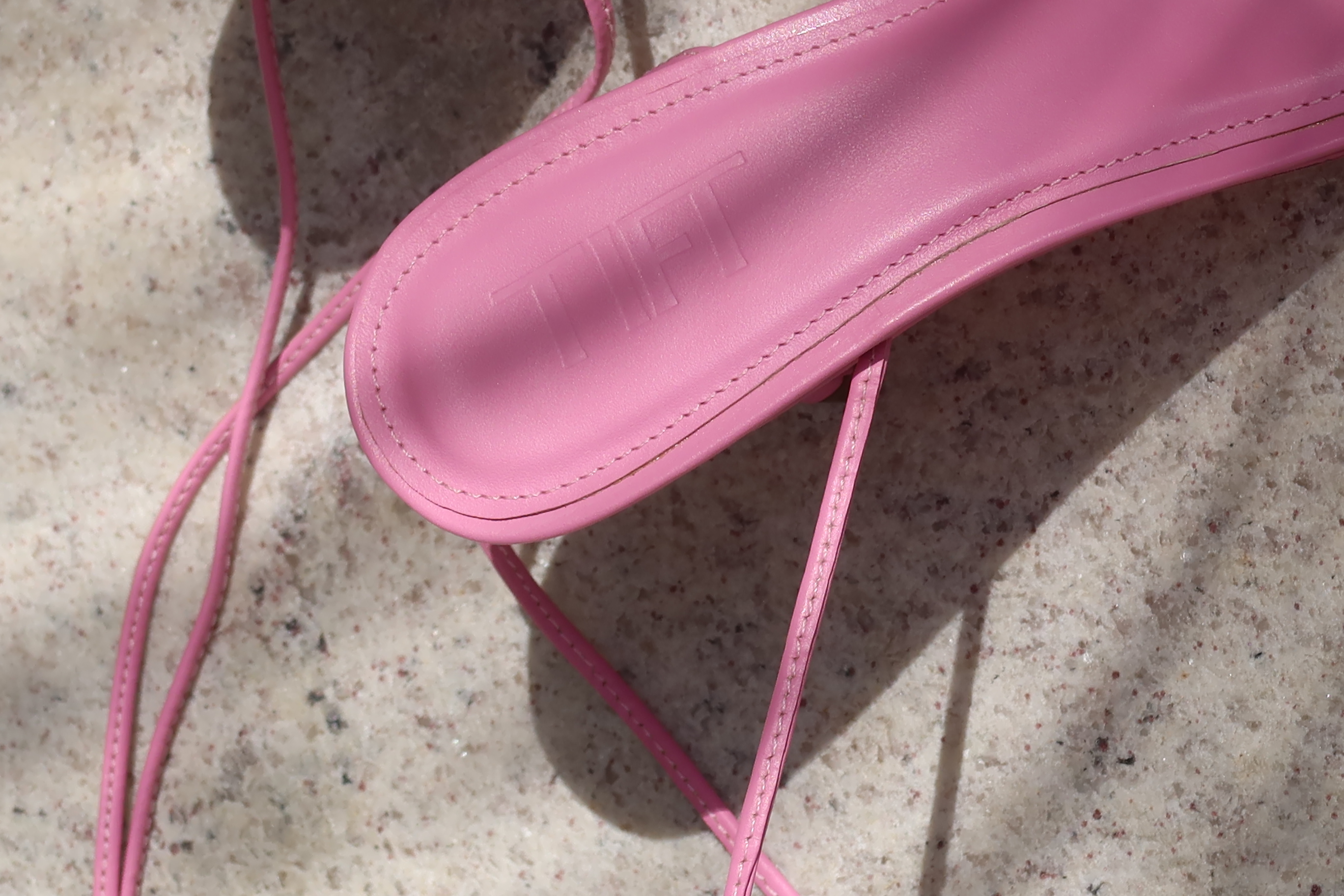 Close-up of the Tift wordmark embossed on a pink shoe